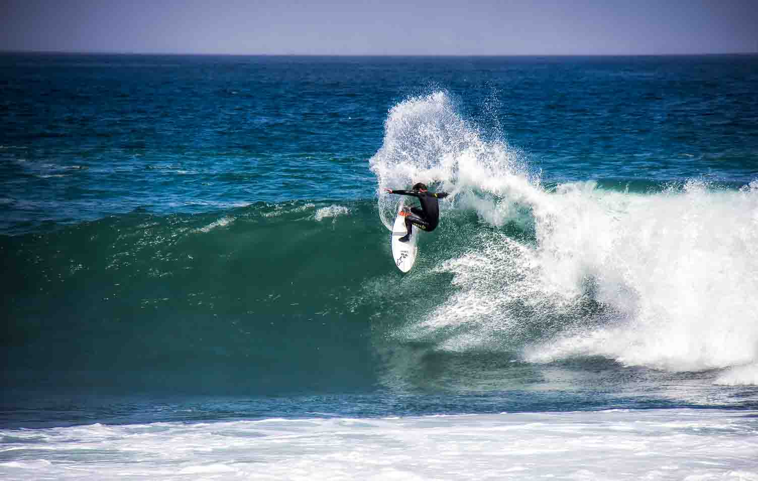 Surfer launching off the lip of a breaking wave