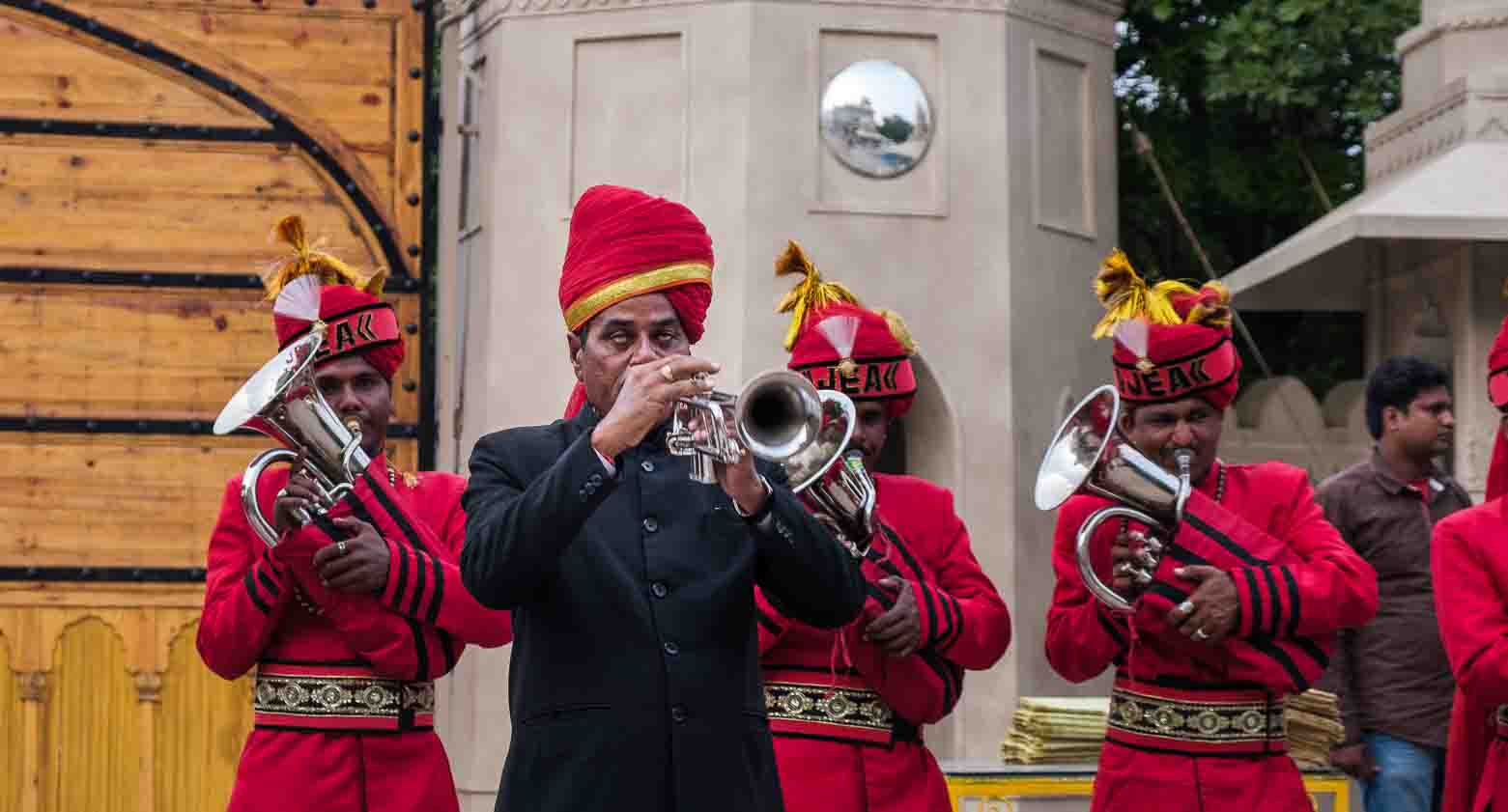 Uniformed wedding band musicians mid-performance on a Jaipur street