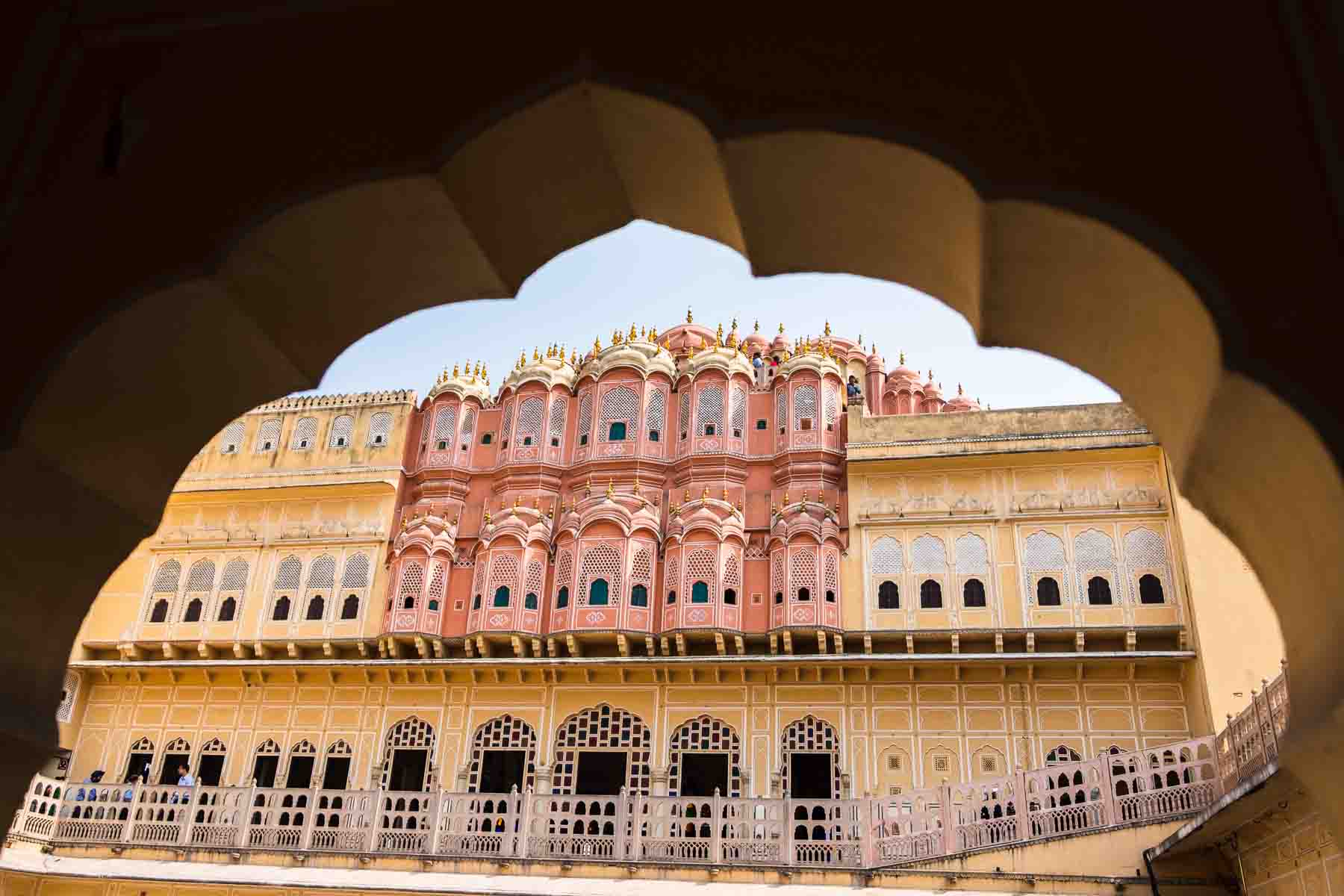 The Hawa Mahal framed through a carved stone archway