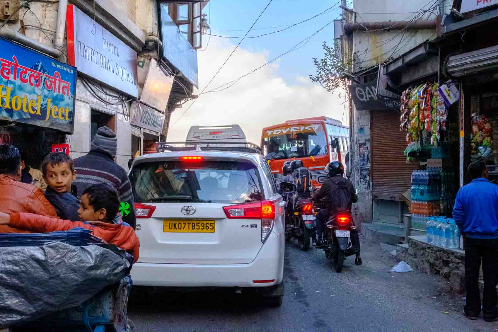 Tour bus and SUV jammed nose-to-tail on a hill-town street